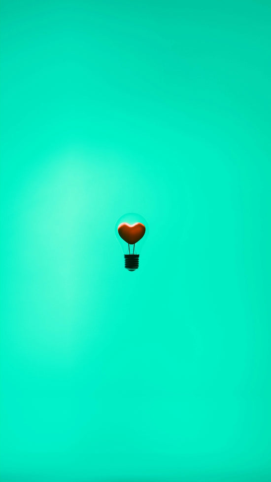 A heart-shaped light bulb floats in the air.