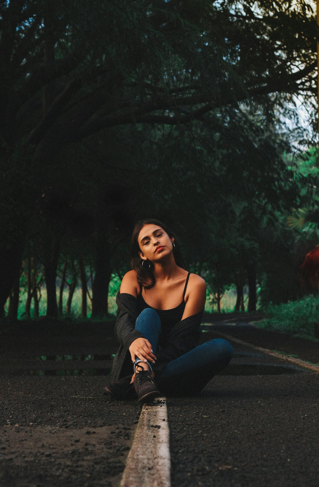 Woman sitting on a road in a forest