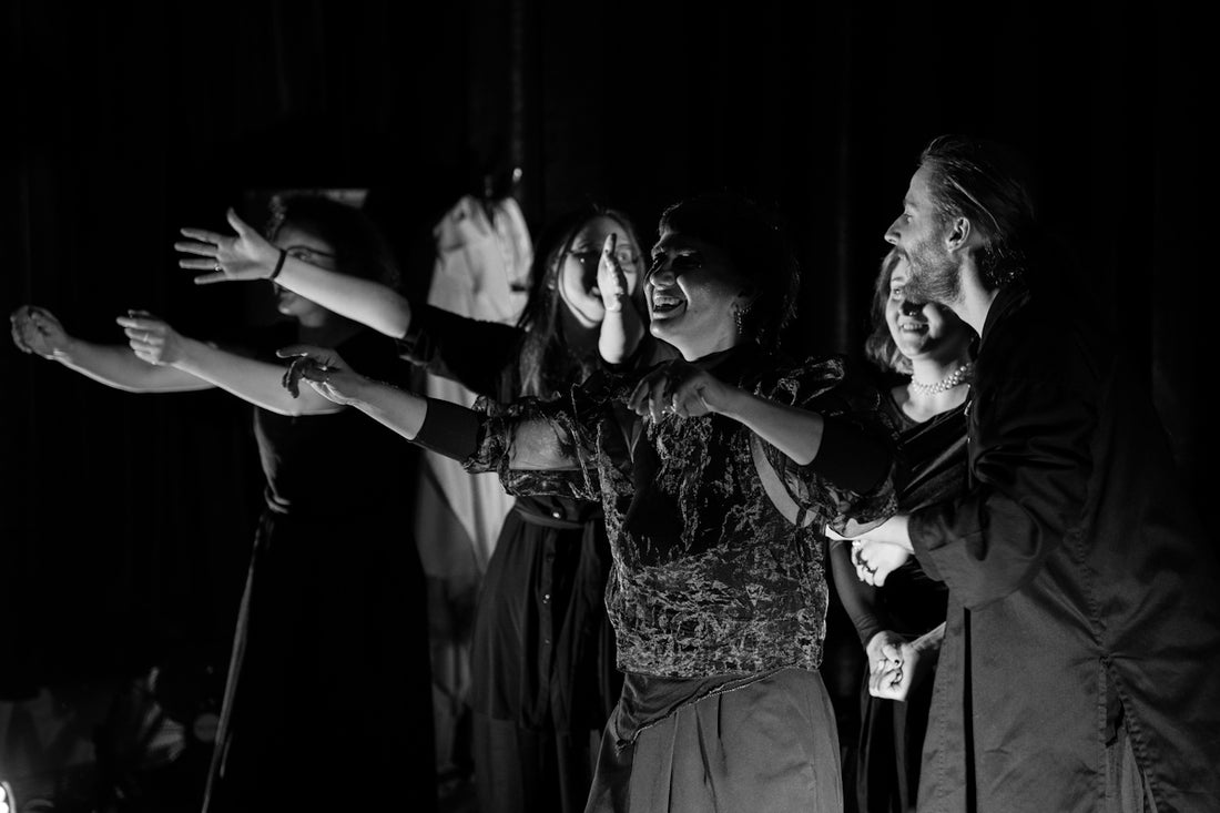 A group of people performing on stage in darkness