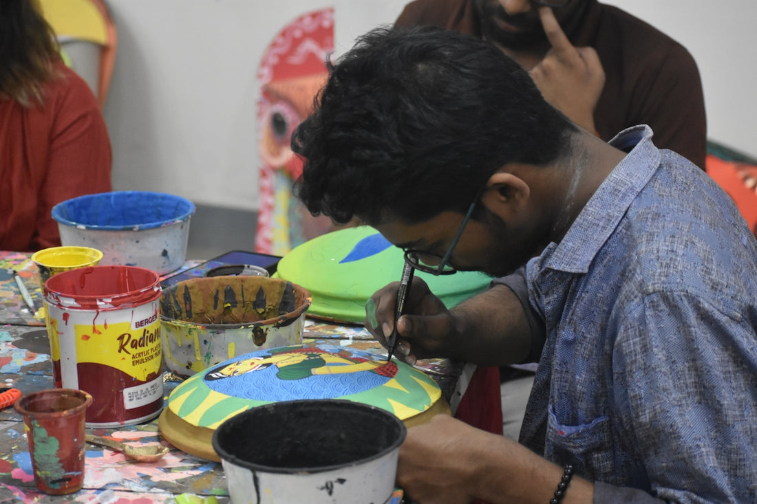 Man painting a colorful object with a brush.
