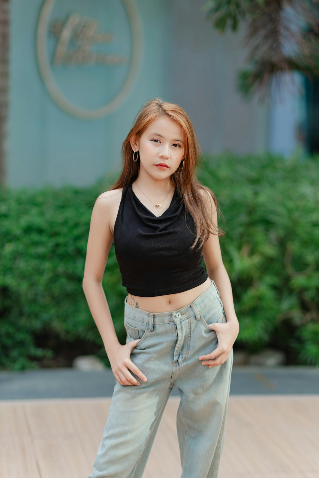 A young woman in a black halter top and jeans